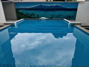 a swimming pool with blue water in a house at Tipanie- Great 1bedroom in PPT, AC w pool & open view in Papeete