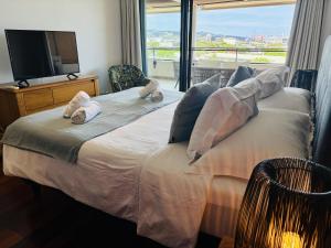 a bedroom with a large bed with a large window at Tipanie- Great 1bedroom in PPT, AC w pool & open view in Papeete +36 photos