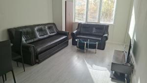 a living room with two black leather couches and a table at UniMuni in Ruse