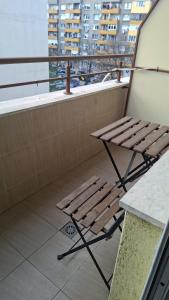 a wooden bench sitting on a balcony with a window at UniMuni in Ruse