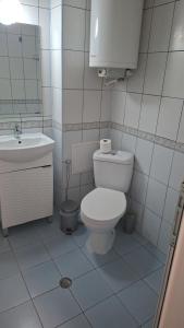 a white bathroom with a toilet and a sink at UniMuni in Ruse +4 photos