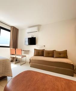 a bedroom with a bed and a desk and a tv at Skylux By Cris Borriello in Rio de Janeiro