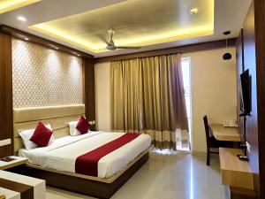 a bedroom with a bed and a desk and a window at Kuber - Palace Premium # Restaurant- Lift and Free Parking Facilities - Fully Air Conditioning Premium Room in Puri