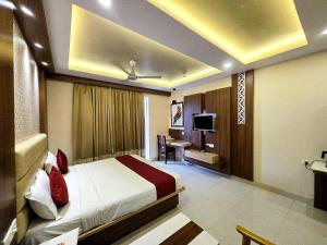 a hotel room with a bed and a television at Kuber - Palace Premium # Restaurant- Lift and Free Parking Facilities - Fully Air Conditioning Premium Room in Puri