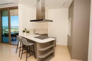 eine Küche mit einer Insel mit Hockern und einer Arbeitsplatte in der Unterkunft 360 Sky Residence, Gym & Pool - 26th Floor in Nikosia