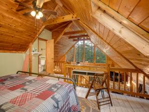 - une chambre dans une cabine avec un lit et un bureau dans l'établissement 1 bedroom with a loft and hot tub cabin 45 minutes to Asheville, à Marion