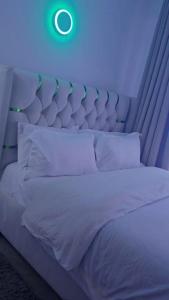 1 dormitorio con 1 cama blanca con luz azul en Neriah paradise, en Nairobi 7 fotos más