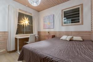 a bedroom with a bed and a desk and a window at Arctic Escape Near Santa Claus Village in Rovaniemi