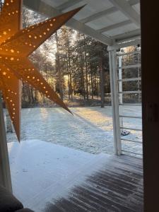 a view of a snow covered yard through a window at Arctic Escape Near Santa Claus Village in Rovaniemi