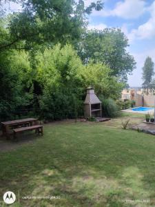 Una mesa de picnic y un cenador en un patio. en Los Eucaliptos, en Tandil