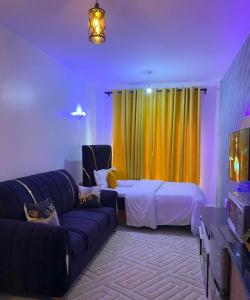 a living room with a couch and a bed and a tv at Tsavo in Nairobi +25 photos