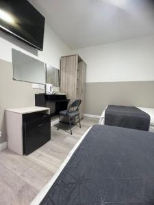 a bedroom with a bed and a desk and a chair at Plaza London Hotel in London