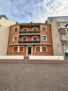 a brick building on a street in front of a building at Sea View in Quend-Plage