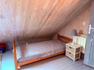 a bed in a room with a wooden ceiling at Sea View in Quend-Plage