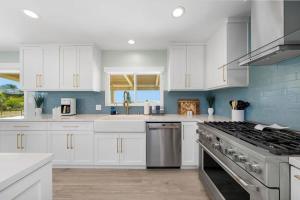 a kitchen with white cabinets and a stove top oven at Family Hilltop luxe retreat with breathtaking views in La Mesa