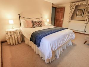 a bedroom with a large bed with white sheets and pillows at Christine's Stable in Crosby Ravensworth