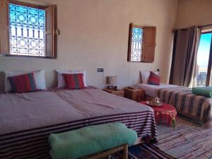 a bedroom with two beds and a couch and a window at LA HACIENDA Agafay Desert  +57 photos