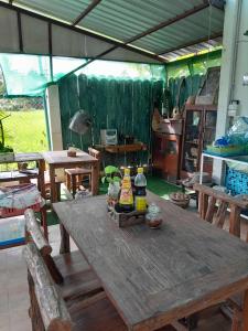a wooden table with bottles on top of it at บ้านอังกาบ Aungkab homestay in Ban Muang Len