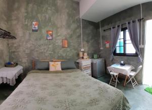 a bedroom with a large bed and a table at บ้านอังกาบ Aungkab homestay in Ban Muang Len