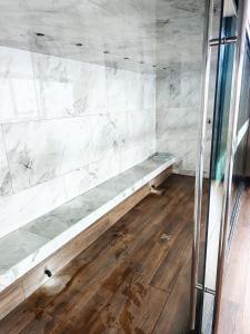 Eine Bank in einem Raum mit Marmorwänden und Holzböden in der Unterkunft Nanotec Studio Equipetrol in Santa Cruz de la Sierra