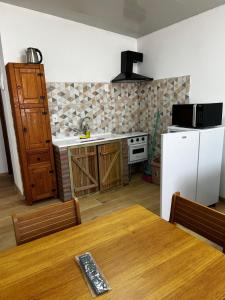 Una cocina con una mesa y un refrigerador blanco. en Chuy Aparts 2, en Chuy
