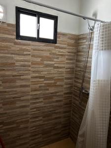 Un baño con ducha con ventana. en Chuy Aparts 2, en Chuy