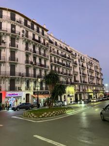 a large building with cars parked in front of it at Charmant studio au cœur dAlger in Alger