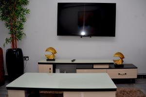 a living room with a white table and a tv at Bomani -4 Summerlake in Kisumu