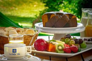 a table with a tray of fruit and a cake at La Dolce Vita Park Hotel in São José dos Pinhais