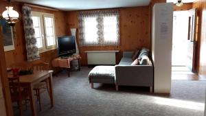 un salon avec un canapé, une table et une télévision dans l'établissement Ferienwohnung Ritz, à Ernen