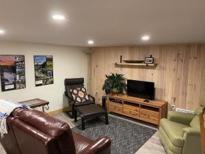 a living room with a couch and a television at Refuge nature en forêt quartier paisible Parc des Chutes in La Tuque