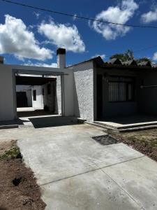 ein weißes Haus mit einer Garage und einer Auffahrt in der Unterkunft Chuy Aparts 1 in Chuy