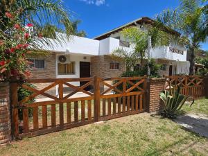 a wooden fence in front of a house at Alojamientos frente al Mar Complejo "El Estar De La Costa" in San Clemente del Tuyú