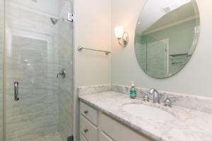 une salle de bain avec un lavabo et une douche avec un miroir dans l'établissement Creekside Cottage, à Edisto Island 35 autres photos