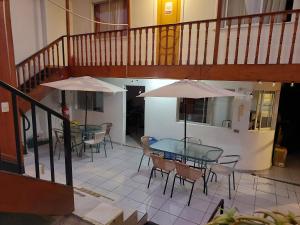 a patio with tables and chairs and a staircase at Hostal aleja in Caldera