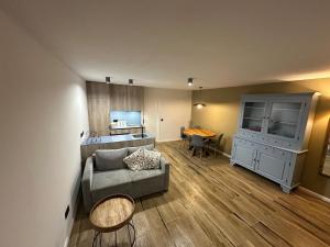 a living room with a couch and a kitchen at Serenity Briolance in Blanquefort-sur-Briolance