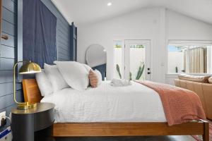 a bedroom with a bed with white sheets and pillows at La Casita - Steps from 7th Ave in Tampa