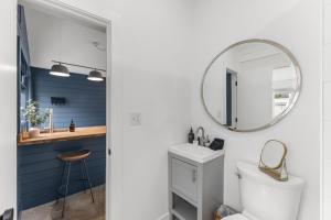 a bathroom with a white toilet and a mirror at La Casita - Steps from 7th Ave in Tampa