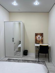 - une chambre avec un miroir et un bureau avec une chaise dans l'établissement Qonys Hostel, à Atyraū