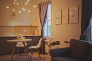 a living room with a table and a kitchen with a window at Gite La Cache in Beloeil Village