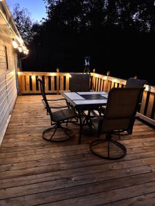 - une table et deux chaises sur une terrasse la nuit dans l'établissement Creekside Cottage, Private, Peaceful, Cozy Escape, à Maryville