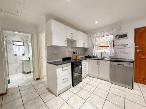 Gulls Nest في هيرمانوس: مطبخ بخزائن بيضاء ومغسلة