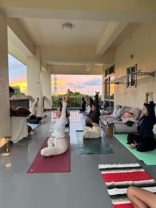 eine Gruppe von Leuten, die in einem Zimmer Yoga machen in der Unterkunft okinawa sup guide in Kunigami