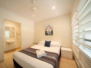 a bedroom with a bed with towels on it at Tropic Sol in Airlie Beach