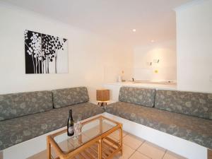 a living room with a couch and a table at Tropic Sol in Airlie Beach