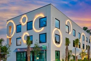a white building with a lit up sign on it at Hotel Circulo in Charleston