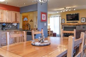 Overlook Athletic Club HeliportBase 9 Aprés Ski Condo: Stroll To Slopes, Downtown的配有木桌的厨房和餐厅