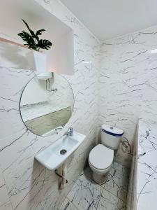 une salle de bain blanche avec toilettes et lavabo dans l'établissement Maison N 20, à Oulad Akkou 6 autres photos