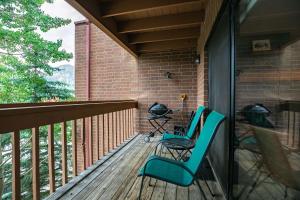 a porch with two chairs and a grill at Lagoon Royal Townhome: Mountain Views Meet Modern Comforts in Frisco