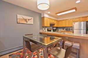 a kitchen with a glass table and chairs in it at Lagoon Royal Townhome: Mountain Views Meet Modern Comforts in Frisco